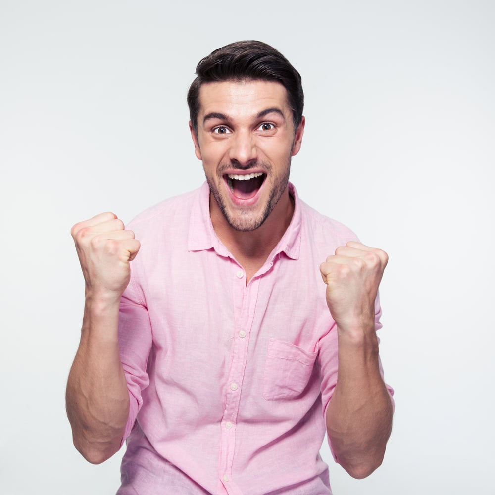 Happy businessman celebrating his success over gray background. Looking at camera Happy businessman celebrating his success over gray background. Looking at camera
